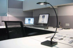 A desk in an office where undercabinet LED highlight a task area.